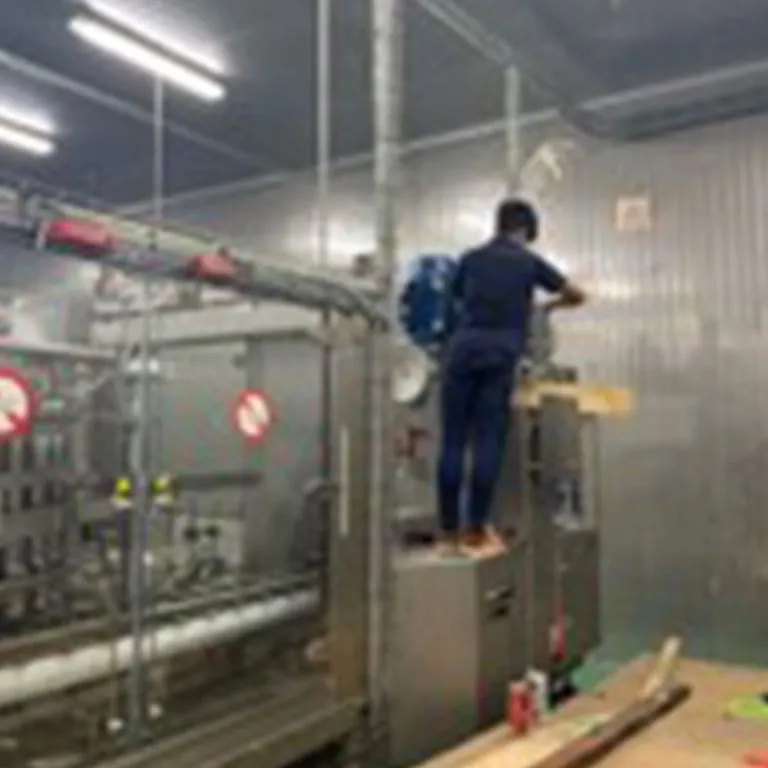 Technician servicing a filling machine on site